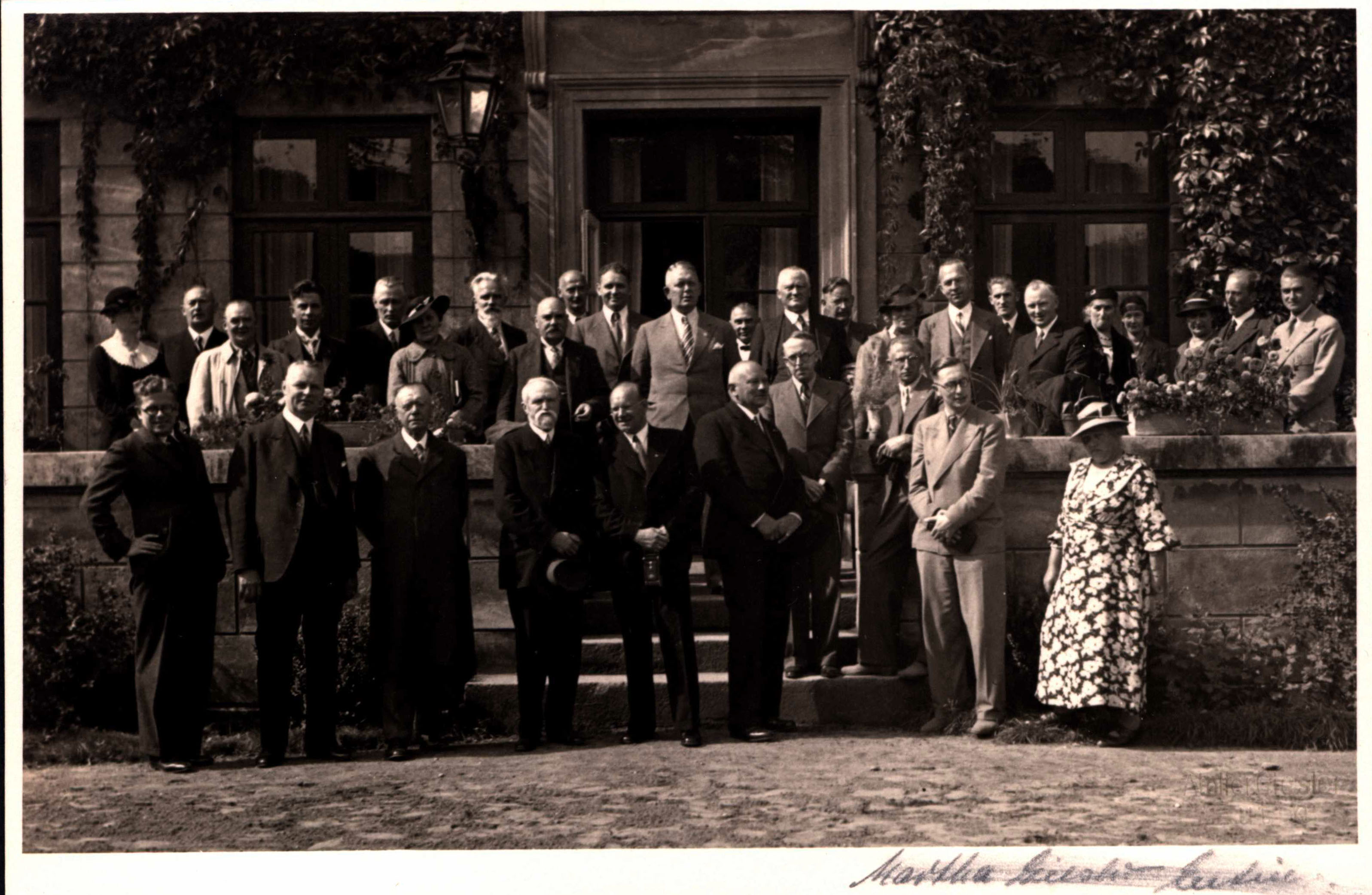 Vordere Reihe, von links nach rechts: 1. Prof. Dr. Gerhard Fricke (Kiel), 2. Dr. Arthur Schäfer (Oberschuldirektor, Eutin), 3. Ottomar Enking, 4. Gustav Frenssen, 5. Hans Ehrke, 6. Carl Westphal, 7. Jochen Schmidt, 8. Hermann Claudius, 9. Heinz Grothe (Zeitungsberichterstatter), 10. Ingeborg Andresen. Hintere Reihe, von links nach rechts: 1. Frau Garber (?), 2. Otto Garber, 3. August Hinrichs, 4. Ernst Behrends, 5. Gustav Friedrich Meyer, 6. Frau Ehrke, 7. Jacob Bödewadt (Ehemann von Ingeborg Andresen), 8. Prof. Andreas Hofmeier (Musikpädagoge und Dirigent, Eutin), 9. Gustav
Peters (Schulleiter, Eutin), 10. Christian Frenzel (Zeitungsberichterstatter), 11. Johann Heinrich Böhmcker (Regierungspräsident und Schirmherr), 12. unbekannt, 13. Prof. Dr. Otto Scheel (Kiel), 14. Waldemar Augustiny, 15. Frl. von Witzleben, 16. Albert Mähl, 17. Herr Wulf, 18. Heinrich Eckmann, 19. Frau von Witzleben, 20. unbekannt, 21. Frau Schäfer, 22. unbekannt, 23. Dr. Hans-Ulrich Ricklefs (Bürgermeister, Eutin).